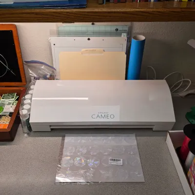 Sale Photo Thumbnail #173: Silhouette Cameo electronic cutting machine with cutting mats and craft materials.