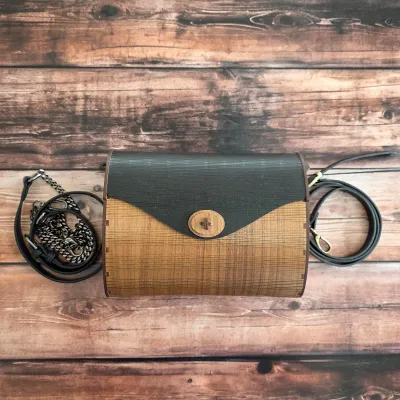 Sale Photo Thumbnail #65: Wooden handbag with curved body, contrasting flap and decorative cutwork sides.