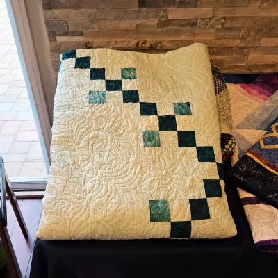 Sale Photo Thumbnail #100: Handmade cream and green patchwork quilt with intricate feather quilting.