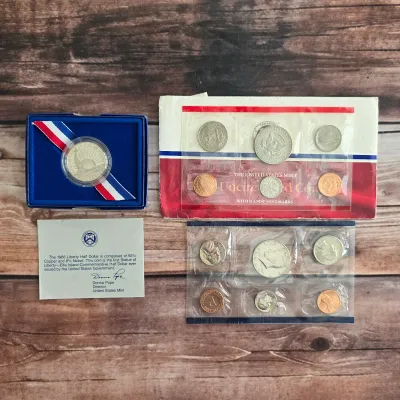 Sale Photo Thumbnail #63: U.S. Mint coin sets and a boxed 1986 Statue of Liberty commemorative half dollar.