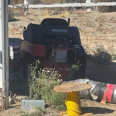 Sale Photo Thumbnail #36: Red and black Snapper rear-engine riding lawn mower parked outdoors.