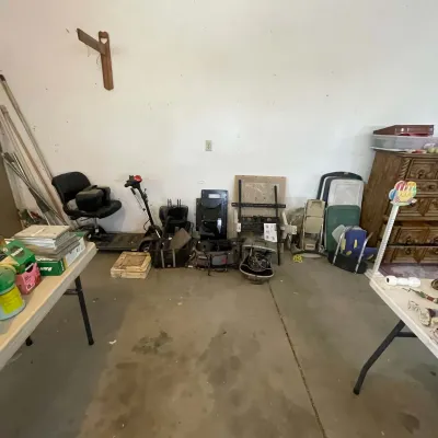 Sale Photo Thumbnail #28: Collection of garage and household goods including a mobility scooter, folding chairs, storage bins, and a carved wooden dresser.