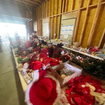 Sale Photo Thumbnail #124: Large assortment of holiday decorations and Christmas items arranged on tables inside a workshop.