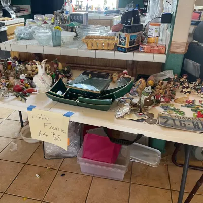 Sale Photo Thumbnail #51: Large collection of small figurines, vintage green ceramic pagodas, glassware, and household knick-knacks arranged on a folding table.