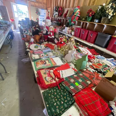 Sale Photo Thumbnail #137: Large collection of vintage Christmas decorations, plush figures, and holiday linens displayed on folding tables.