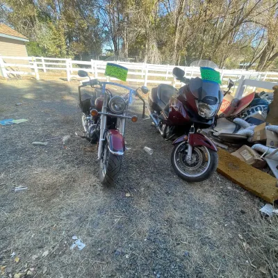 Sale Photo Thumbnail #128: Two maroon motorcycles, including a 2001 Yamaha V-Star 650 cruiser and a Honda touring bike, parked outdoors.