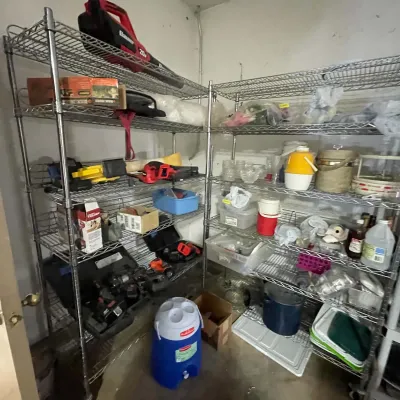 Sale Photo Thumbnail #24: Metal wire shelving units loaded with assorted power tools, hardware supplies, plastic beverage coolers, and general household garage items.