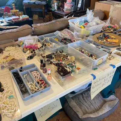 Sale Photo Thumbnail #61: Large collection of vintage costume jewelry, including beaded necklaces, faux pearls, and bracelets, organized in plastic bins and trays on a table.