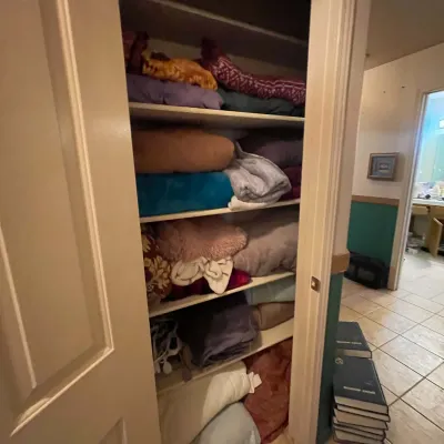 Sale Photo Thumbnail #63: Linen closet packed with assorted folded blankets, pillows, and bedding textiles.