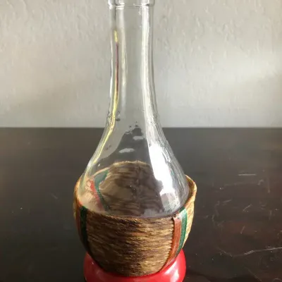 Decorative Glass Bottle with Woven Straw Wrap and Red Base