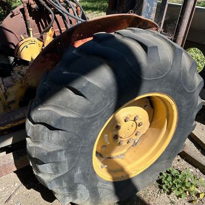 Sale Photo Thumbnail #128: Vintage industrial tractor fitted with a forklift mast attachment and large Armstrong rear tires, showing weathered orange paint and exposed hydraulic controls.