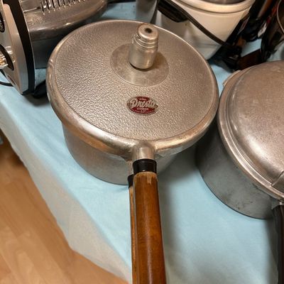 Sale Photo Thumbnail #34: Vintage National Presto cast aluminum 4-quart pressure cooker with wooden handle and top pressure regulator gauge.