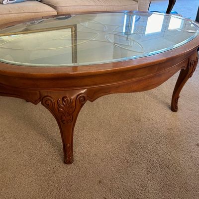 Sale Photo Thumbnail #188: Traditional oval wood coffee table with a glass top insert featuring etched geometric designs and carved French provincial-style cabriole legs.