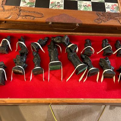 Sale Photo Thumbnail #78: Vintage Asian carved wooden chess set featuring a hand-carved game board box with a red felt-lined storage drawer containing dark figurines.