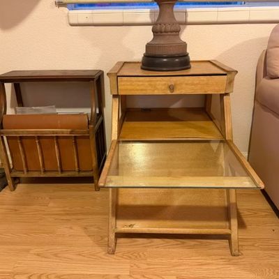 Sale Photo Thumbnail #194: Mid-century blonde wood step-up nightstand with a pull-out glass shelf alongside a vintage wooden magazine rack side table.