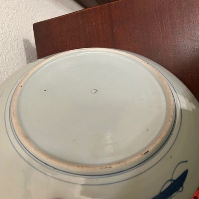 Sale Photo Thumbnail #101: Underside of an Asian blue and white ceramic bowl featuring concentric blue ring details and an unglazed foot rim.