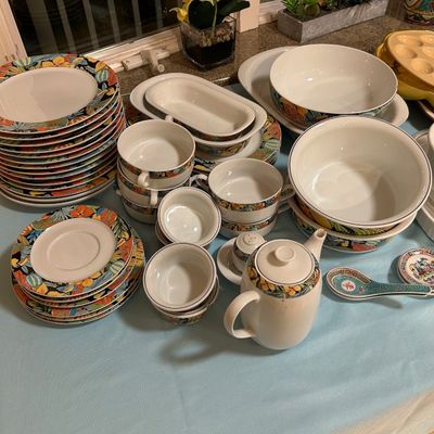 Sale Photo Thumbnail #36: Large set of dinnerware featuring a colorful floral and foliage border, including plates, bowls, cups, and a matching teapot.