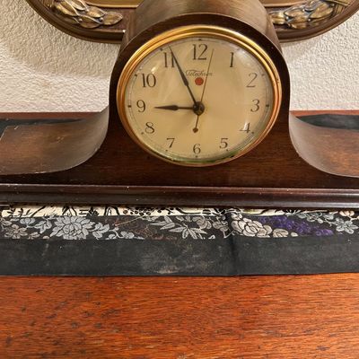Sale Photo Thumbnail #102: Vintage Telechron wood tambour mantle clock featuring a brass-bezeled dial and red dot indicator window, showing light surface wear.