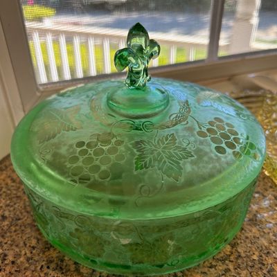 Sale Photo Thumbnail #21: Vintage green Depression glass covered powder jar featuring a fleur-de-lis finial and etched grape and vine motif.