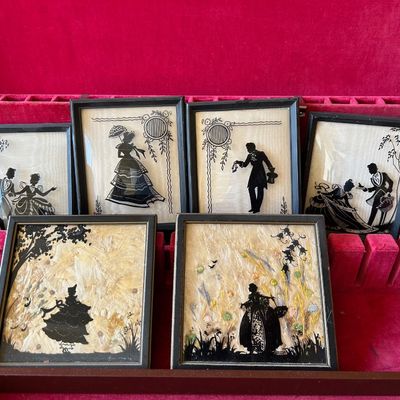 Sale Photo Thumbnail #137: Collection of six framed vintage silhouette pictures featuring Victorian-style figures and floral backgrounds, displayed in a red velvet-lined box.