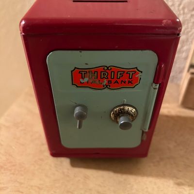 Sale Photo Thumbnail #70: Vintage red and light green metal Thrift Dial Bank toy safe, featuring a coin slot on top and combination dial mechanism on the front door.
