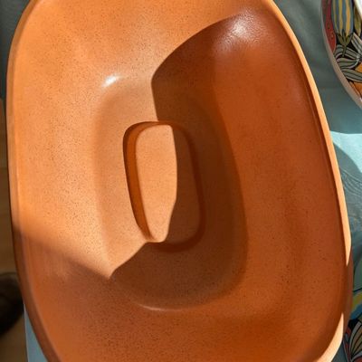 Sale Photo Thumbnail #106: Terracotta oval baking dish or lid, featuring a smooth, matte finish with fine speckling throughout.
