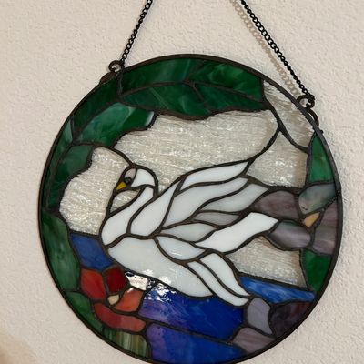 Sale Photo Thumbnail #16: Round stained glass suncatcher featuring a white swan swimming on water, framed by green leaves with a hanging chain attached.