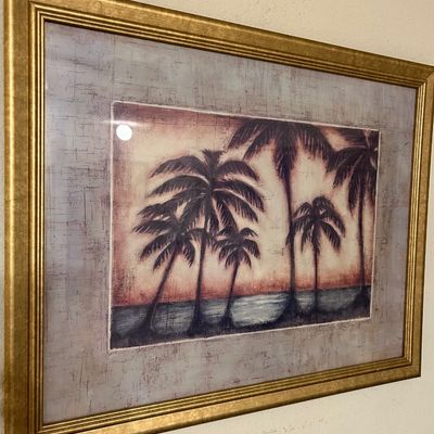 Sale Photo Thumbnail #80: Framed tropical art print featuring silhouettes of palm trees along a shoreline, housed in a thick molded gold-toned frame.