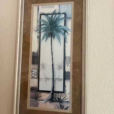 Sale Photo Thumbnail #183: Framed tropical palm tree art print featuring a tall central palm tree against an architectural and abstract background, presented in a double-matted silver and white frame.