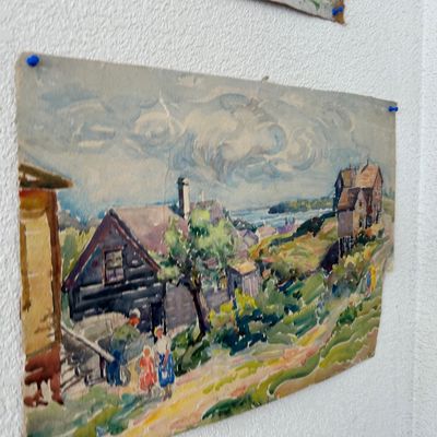 Sale Photo Thumbnail #169: Unframed vintage watercolor painting depicting a coastal village scene, pinned to a wall with blue thumbtacks.