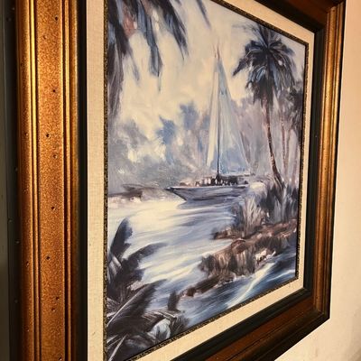Sale Photo Thumbnail #93: Framed impressionistic oil painting on canvas depicting a sailboat near a palm-lined tropical shore, presented in a ornate gold and dark wood frame with a linen mat.