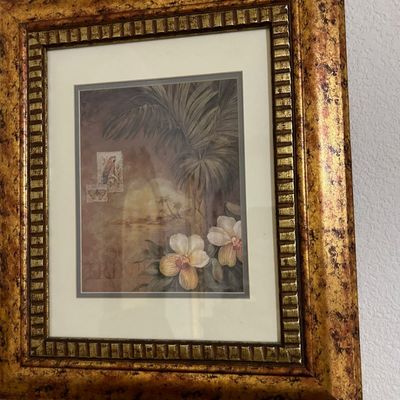 Sale Photo Thumbnail #18: Framed tropical botanical art print featuring orchids, palm trees, and stamp motifs set within an ornate mottled gold frame.