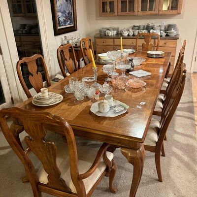 Sale Photo Thumbnail #95: Large wooden dining table with cabriole legs and eight matching vaseback chairs, display-laden with crystal glassware, Depression glass, and china set pieces.