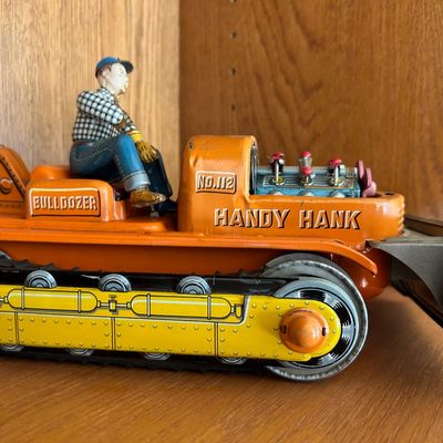 Sale Photo Thumbnail #113: Vintage mid-century tin litho wind-up "Handy Hank No. 112 Bulldozer" toy featuring a driver figure and detailed engine.