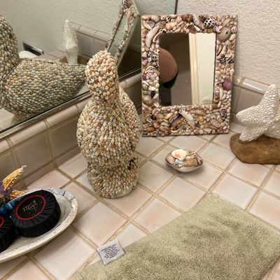 Sale Photo Thumbnail #66: Collection of coastal-themed decor items including a seashell-encrusted mirror frame, bird sculptures, a starfish figurine, and a shell soap dish.