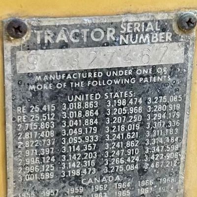 Sale Photo Thumbnail #130: Massey Ferguson tractor serial number plate mounted on a yellow metal frame.