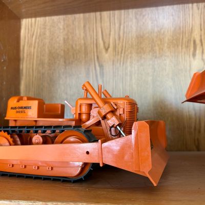 Sale Photo Thumbnail #114: Vintage orange Allis-Chalmers diesel crawler tractor toy with front dozer blade and rubber tracks.