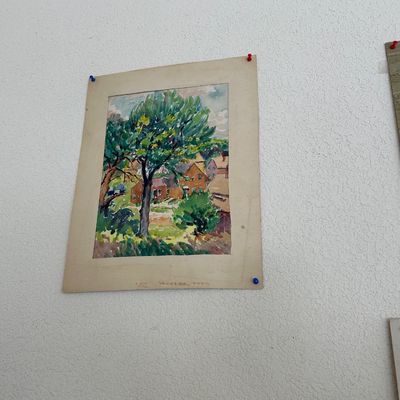 Sale Photo Thumbnail #167: Unframed original watercolor painting depicting a village landscape with houses and trees, mounted on a cream-colored mat board.