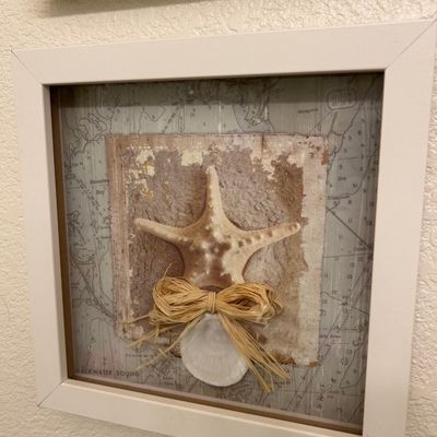 Sale Photo Thumbnail #68: Framed coastal shadow box artwork featuring a real starfish, shell, and raffia bow against a nautical map background.