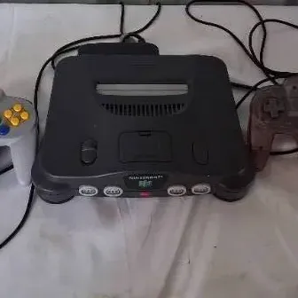 Nintendo 64 video game console, model NUS-001, complete with one standard gray controller and one translucent Atomic Purple controller.