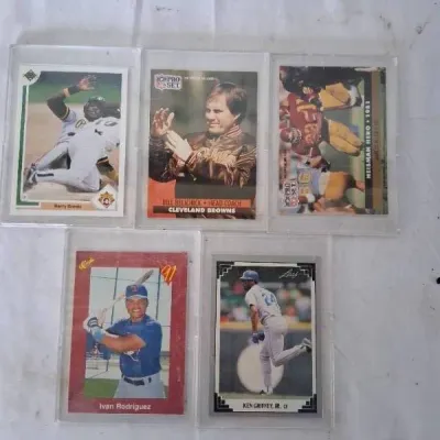 Collection of five vintage sports trading cards in protective plastic cases, featuring Barry Bonds, Bill Belichick, Marcus Allen, Ivan...