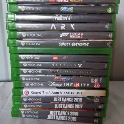 Stack of 15 video games for Xbox One, including titles like Fallout 4, Grand Theft Auto V, and Just Dance.