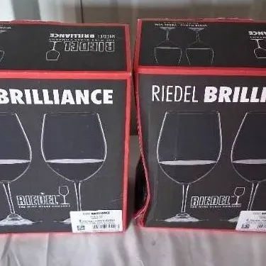 Two boxed sets of Riedel Brilliance wine glasses, each appearing unused in original packaging.