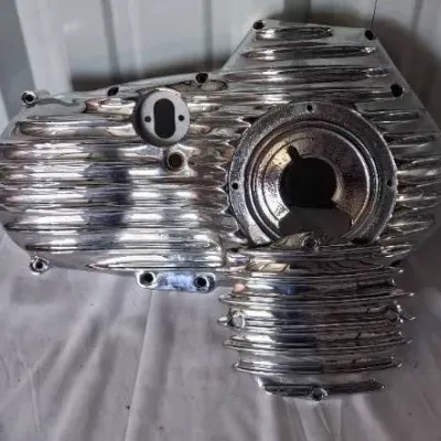 Polished chrome ribbed inner primary cover set for a motorcycle, in clean condition.