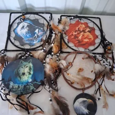 Collection of Native American style dreamcatchers featuring printed artwork of eagles, horses, and wolves, adorned with feathers and beads.