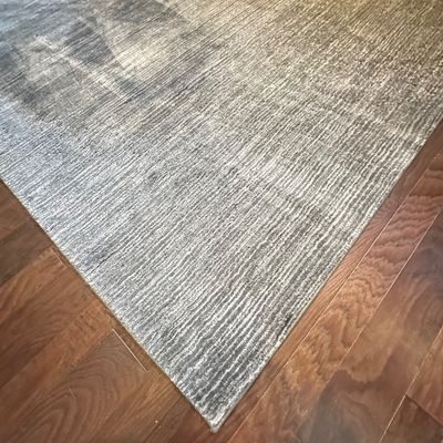 Sale Photo Thumbnail #111: Contemporary textured area rug in shades of grey and cream, laid over hardwood flooring.