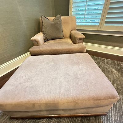 Sale Photo Thumbnail #109: Contemporary velvet armchair and oversized matching ottoman set in a muted greige finish, accented with nailhead trim and an included throw pillow.