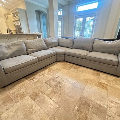 Sale Photo Thumbnail #90: Large L-shaped sectional sofa with light grey woven fabric upholstery and rolled arms.
