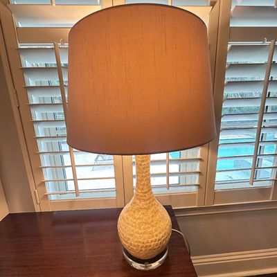 Sale Photo Thumbnail #97: Mid-century style textured ceramic table lamp with a teardrop base, clear acrylic pedestal, and a beige drum shade.