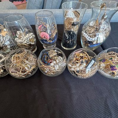Sale Photo Thumbnail #5: Large collection of costume jewelry, sorted and displayed inside ten clear glass vases and bowls.